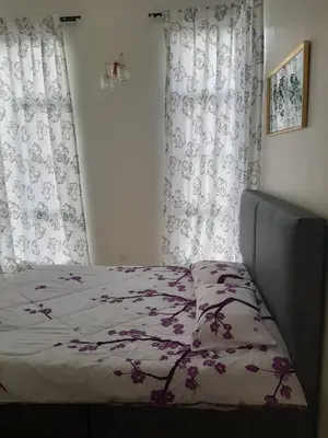a bedroom with a bed with a flower patterned blanket at MK Homestay Sunway in Ipoh