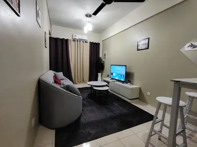 a living room with a couch and a television at Firza Suite in Gua Sai
