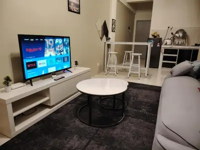 a living room with a tv and a table at Firza Suite in Gua Sai