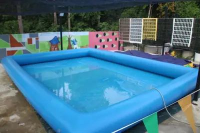 a large blue inflatable pool in a yard with a fence at Capital O 91187 D'dusun Raudhah Chalet in Baling