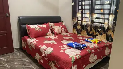 a bed with a red comforter and pillows at Capital O 91191 Chalet Cd Impiana in Kulim