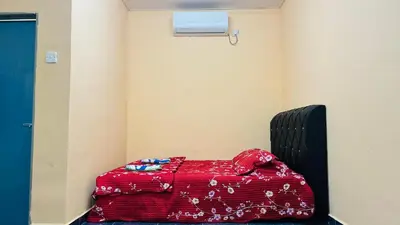 a bed in a room with a red blanket at Capital O 91191 Chalet Cd Impiana in Kulim