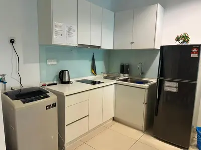 a kitchen with white cabinets and a black refrigerator at Mansion One Seaview Studio 4 pax Gurney in George Town