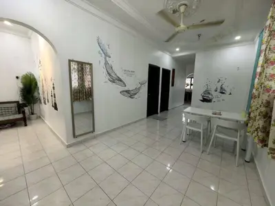 a room with a table and paintings on the wall at Queen Bed Budget Room in Padang Serai