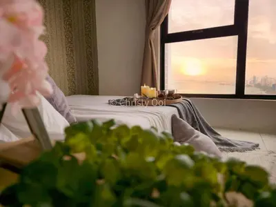 a room with a bed and a window with candles at NEW 2BR Sunrise Gurney with Stunning Seaview \u65e0\u654c\u65e5\u51fa\u6d77\u666f\u623f in George Town