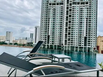 a pool with a table and chairs and a building at Georgetown 2BR Luxury Condo Unbeatable Night View Infinity Pool Attractions Food Fully Equipped#148B in Bayan Lepas
