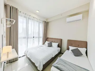 two beds in a room with a window at Stylish city center infinity pool unbeatable night view near to attractions, food, family friendly in Jelutong