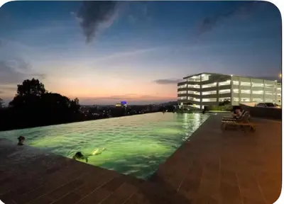 a large swimming pool in front of a building at Dandelion 3BR Apt Near lake garden in Taiping