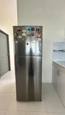 a stainless steel refrigerator in a kitchen with many magnets at Mimi's Nest - Fully furnished, wifi at Tronoh in Teronoh
