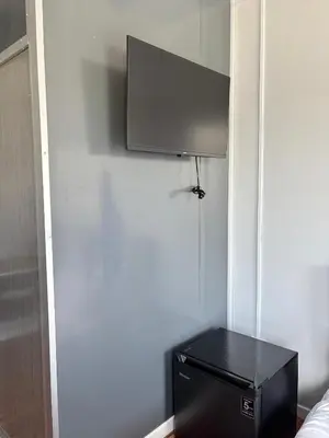 a flat screen tv on a wall in a bedroom at Roomstay Kontena Sungai Bioh in Gua Sai