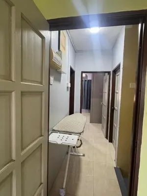a room with a door and a chair in a hallway at Homestay NIA Chukai in Gua Sai