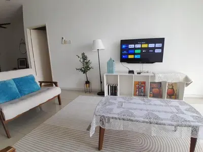 a living room with a table and a tv at Condominium Crystal Heights in Taiping