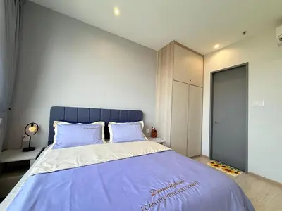 a bedroom with a large bed with a blue headboard at Iconic Regency Service Residences - Bee's Home in Bayan Lepas