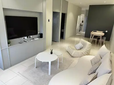a living room with a white couch and a tv at Tanah Rata Cameron Jaya cottage has plenty of hot water, a spacious living room in Tanah Rata
