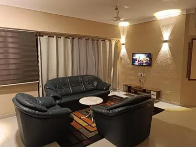 a living room with two leather chairs and a table at Sri Sayang Resort Apartment in Batu Ferringhi