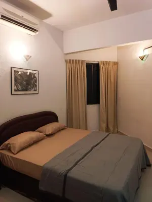 a bedroom with a large bed in front of a window at Sri Sayang Resort Apartment in Batu Ferringhi