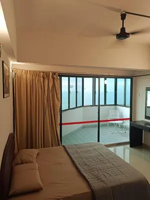 a bedroom with a bed and a balcony at Sri Sayang Resort Apartment in Batu Ferringhi