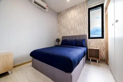 a bedroom with a bed with blue sheets and a window at IconicRegency #3BR #USM #Queensbay #Airport in Bayan Lepas