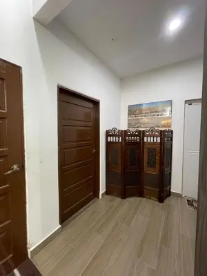 a room with two doors and wooden floors at Laman Serambi Homestay in Hutan Melintang