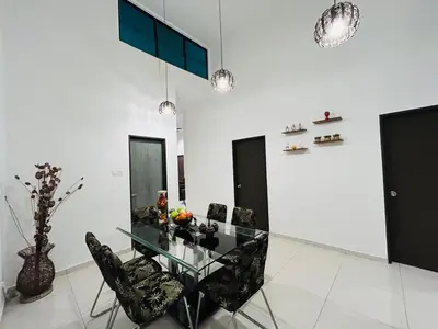 a dining room with a glass table and black chairs at Ethereal Ipoh Homestay in Ipoh