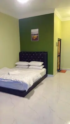 a bed in a room with a green wall at TGB Buhayra CHALLET & CAMPSITE