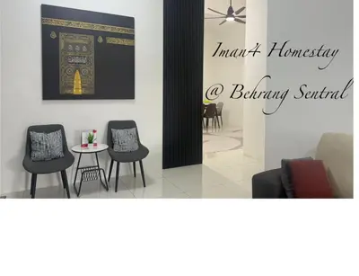 a room with chairs and a table with a picture on the wall at Iman4 Homestay in Kampung Behrang