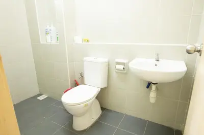 a bathroom with a toilet and a sink at Spacious 4BR Double Storey Home Balik Pulau in Balik Pulau