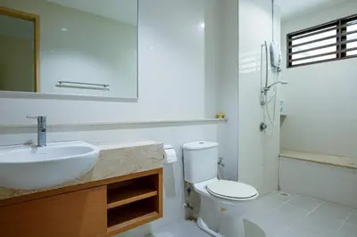 a bathroom with a sink and a toilet and a mirror at Spacious 4BR Double Storey Home Balik Pulau in Balik Pulau