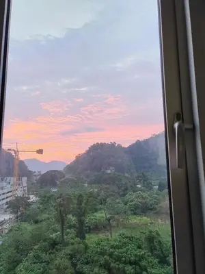 a window with a view of a mountain at Ipoh Anderson Suites in Ipoh