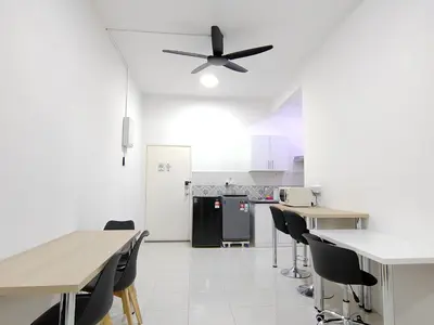 a kitchen with tables and chairs and a ceiling fan at Ipoh Anderson Suites in Ipoh