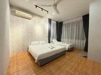 a bedroom with two beds in a room at Relax Guest House Taman Merak Jaya Simpang Ampat in Simpang Ampat