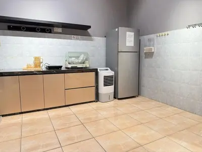 a kitchen with a refrigerator and a counter top at Relax Guest House Taman Merak Jaya Simpang Ampat in Simpang Ampat