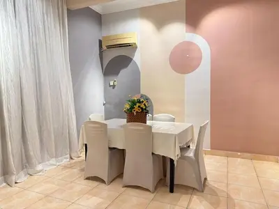 a dining room with a white table and chairs at Relax Guest House Taman Merak Jaya Simpang Ampat in Simpang Ampat