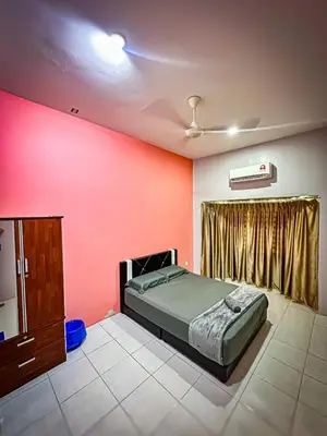 a bedroom with a bed and a red wall at Sofea Homestay Raban Lake in Kampong Kuala Chegar
