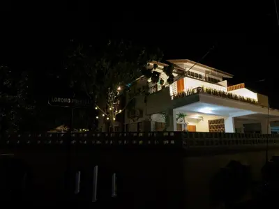 a white house with a balcony at night at D SeBalik Pulau Tropical Boutique Home in Balik Pulau