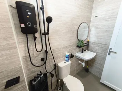a bathroom with a toilet and a sink and a microphone at Spacious, 2 Storey Home, Up to 12 Pax, 4 Bedrooms, 4 Bathrooms, 2 Car Park Lots by Star Home in Sungai Petani