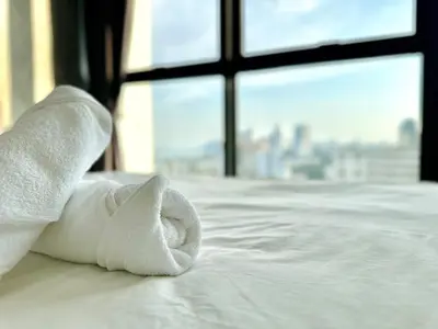a white towel sitting on a bed with a window at Cozy Sea & City View Penang, 3BR-10PAX b30 in George Town