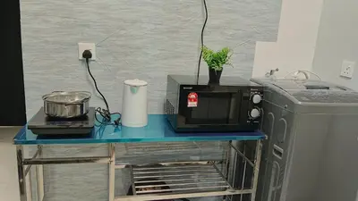 a microwave on a blue table next to a refrigerator at relax familystay Urban suites 3BR-10pax b30 in George Town