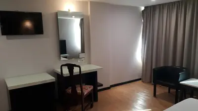 a hotel room with a desk and a mirror at Red Rock Hotel Penang in George Town