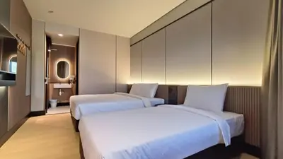 two beds in a hotel room with white sheets at Urban Inn, Cengal Jaya in Sungai Petani
