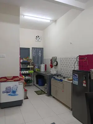 a kitchen with a counter and a refrigerator at Homestay Ismail LEKIR in Sitiawan