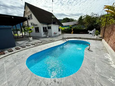 a large blue swimming pool in a yard at Lakeside Pool Villa in LakeGarden & Zoo in Taiping