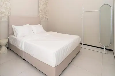 a white bedroom with a bed with white sheets at Creamy French at Urban Suite in George Town