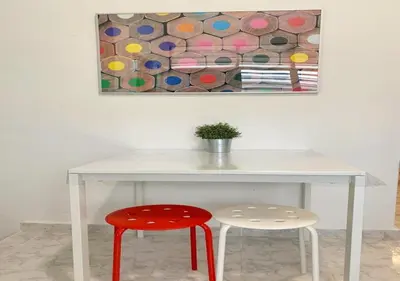 a white table with two stools and a painting at Ria Serene Homestay in Sungai Petani