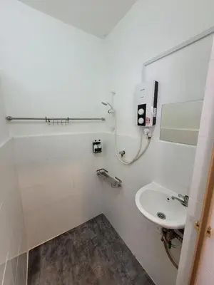 a white bathroom with a sink and a mirror at Ria Serene Homestay in Sungai Petani