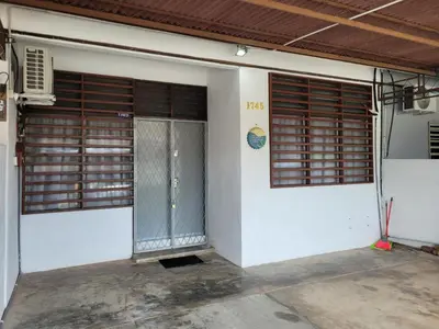 a white building with two doors and aliction at Ria Serene Homestay in Sungai Petani