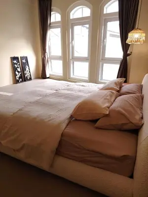 a large bed in a bedroom with two windows at Mokū Georgetown Pre-war House 4BR 5-14pax in George Town