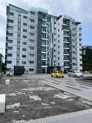 a parking lot with cars in front of a large building at Imagine world quintet apartment in Tanah Rata