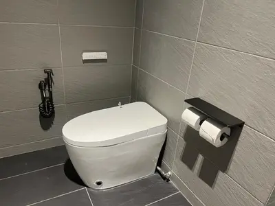 a bathroom with a toilet and a phone on the wall at Canning Home in Ipoh