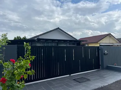 a black fence with a gate in front of a house at Canning Home in Ipoh